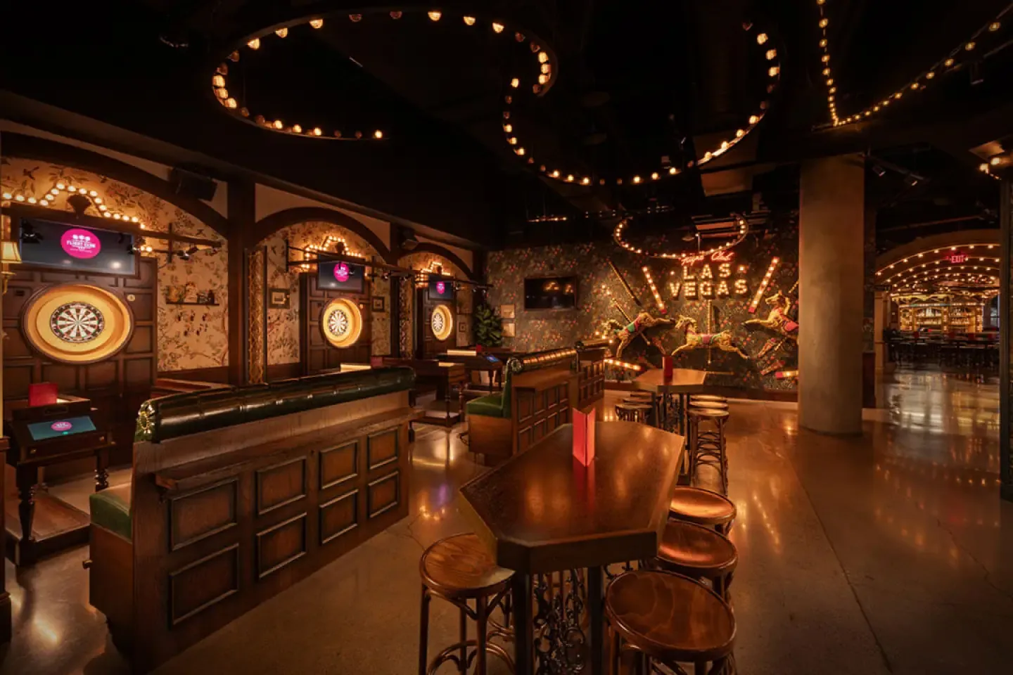 Lit dartboard bays and high tables under marquee lighting at Flight Club Las Vegas