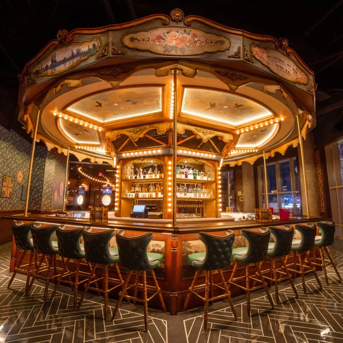 The carousel bar at Flight Club, ringed with bulb lighting and green leather stools